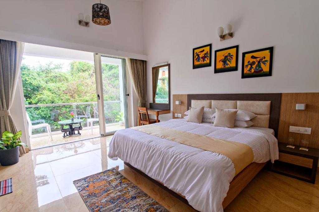 桑戈尔达Lotus & Orchid Villas by Ramnath Homes的一间卧室设有一张大床和一个大窗户