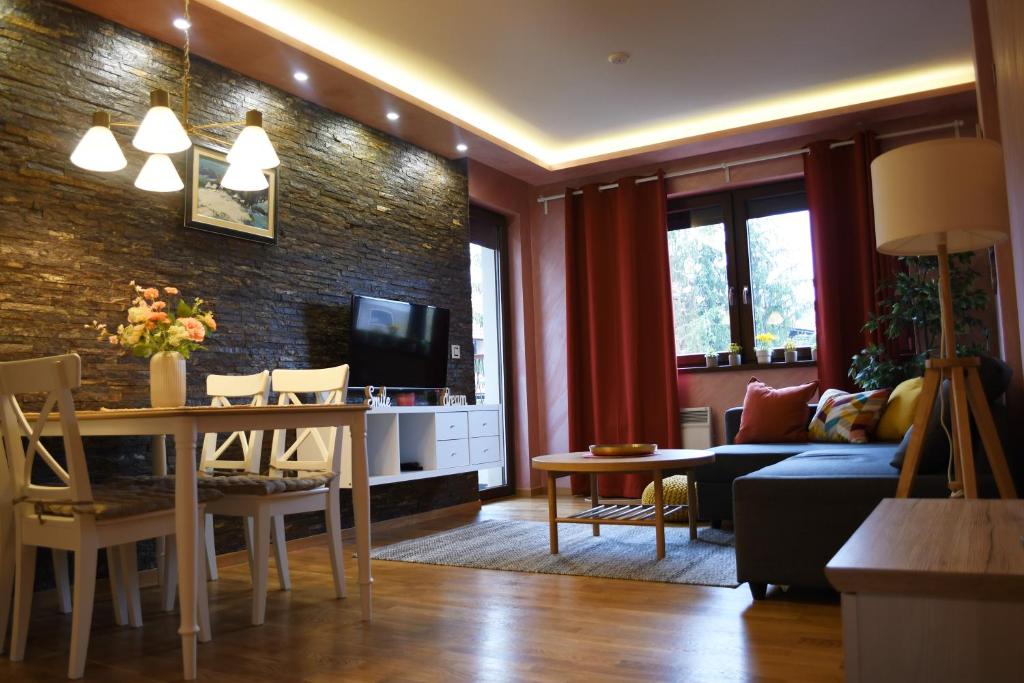 兹拉蒂博尔Apartman Dream的带沙发的客厅和用餐室