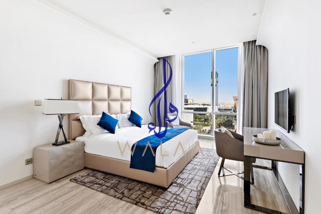 利雅德Walaa Homes-Luxury 1Bedroom at DAMAC Esclusiva Tower Riyadh Saudia-708的酒店客房配有一张床、一张书桌和一台电视。