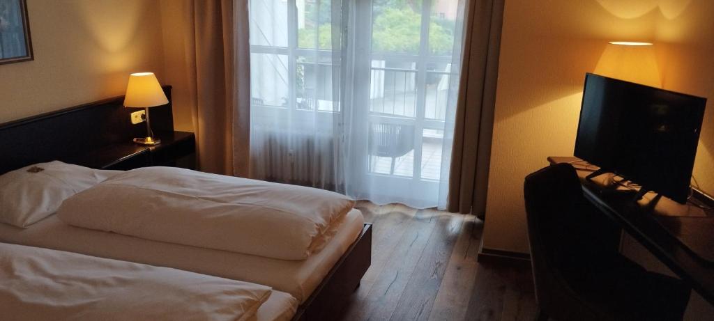 施韦青根剧院酒店的一间卧室配有一张床、一台电视和一个窗口