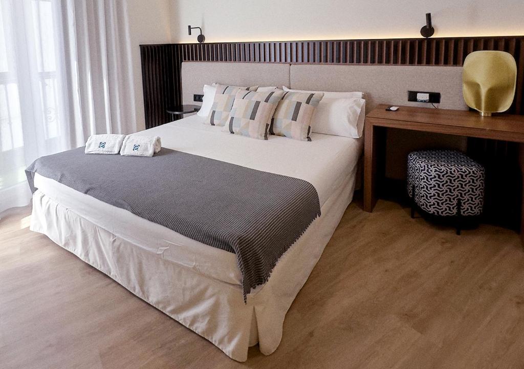 塞维利亚ISA Sevilla Suites的一间卧室配有一张大床和一张书桌