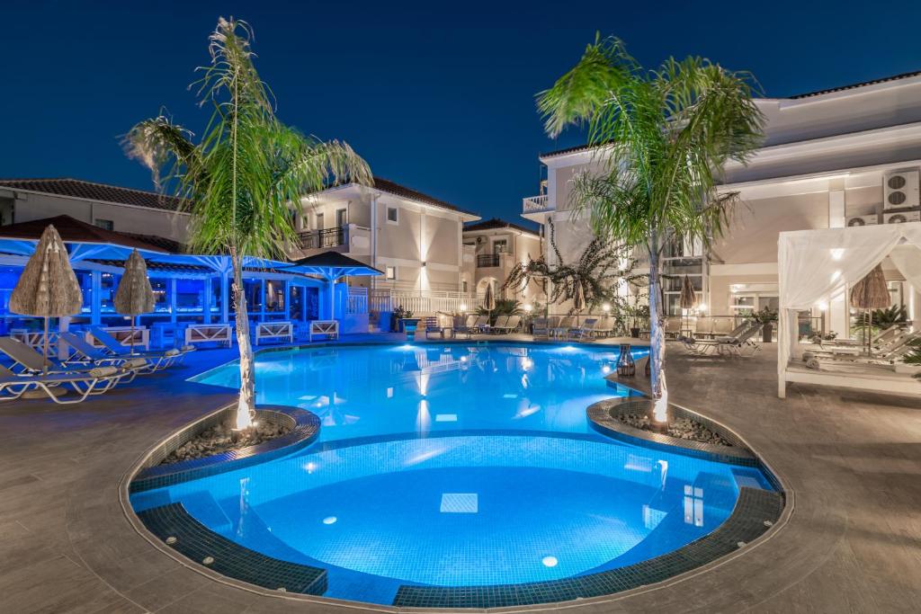 拉加纳斯Tzante Hotel Zakynthos, Adults Only的中间有两棵棕榈树的游泳池