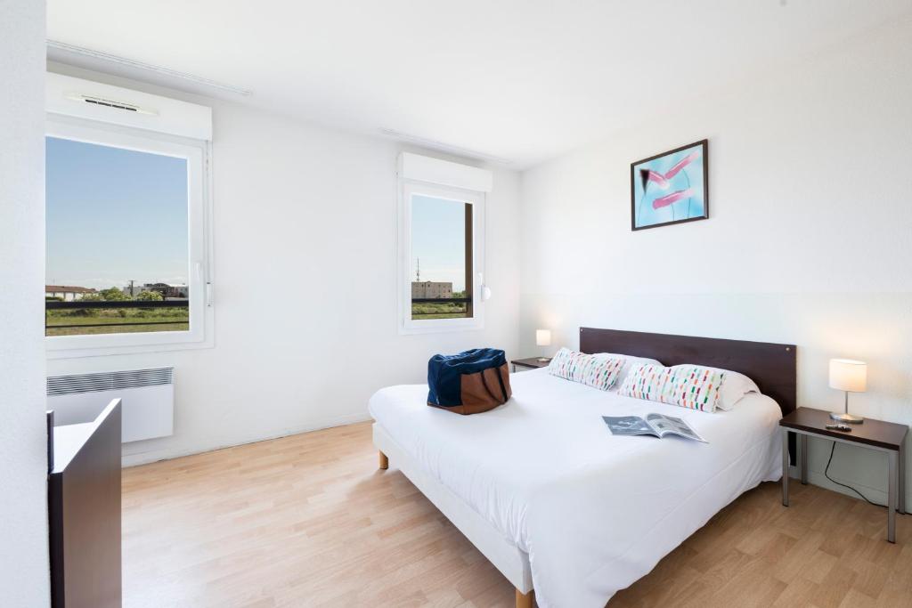热尔扎克莱蒙费朗 - 格尔扎特花园和城市公寓的一间白色卧室,配有床和2个窗户