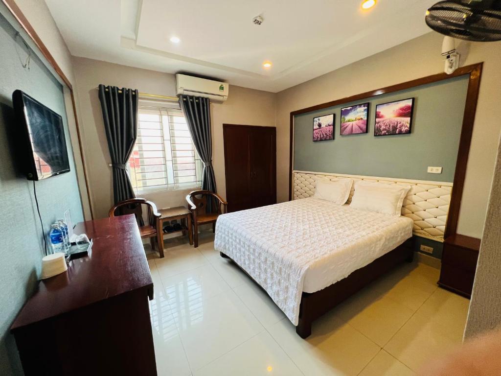 荣市Hoang Ngan 1 Hotel - TP. Vinh的酒店客房带一张床、一张桌子和椅子