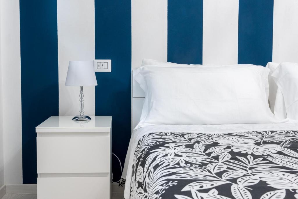 波尔图桑特埃尔皮迪奥Resilienza Tropical Apartments & Room的一间卧室配有一张床和一个带灯的床头柜