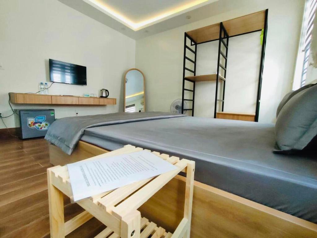 海防Hương Cảng Homestay的一间卧室配有一张大床、椅子和一张桌子