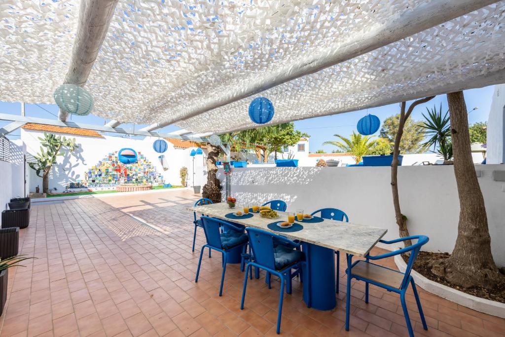 西尔韦斯Porta 27的庭院配有桌子和蓝色椅子