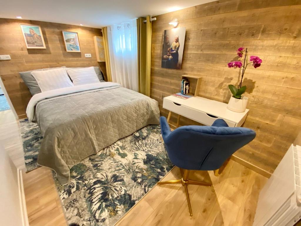 瑟堡Appartament Bel Air的一间卧室配有一张床和一张蓝色椅子