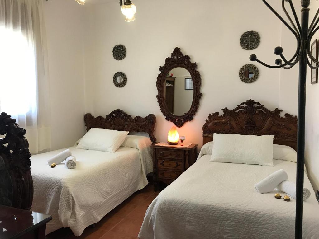 滨海罗克塔斯Casa Pedro的一间卧室配有两张床和镜子