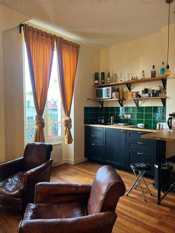 巴黎Villa Ermitage-Appartement Paris - Buttes Chaumont的厨房配有沙发、椅子和桌子