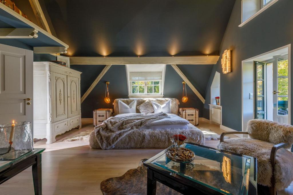 伊尔森堡Luxus Hotel Design Villa Ottilienruh Ilsenburg im Harz的一间卧室配有一张床、一张沙发和一张桌子
