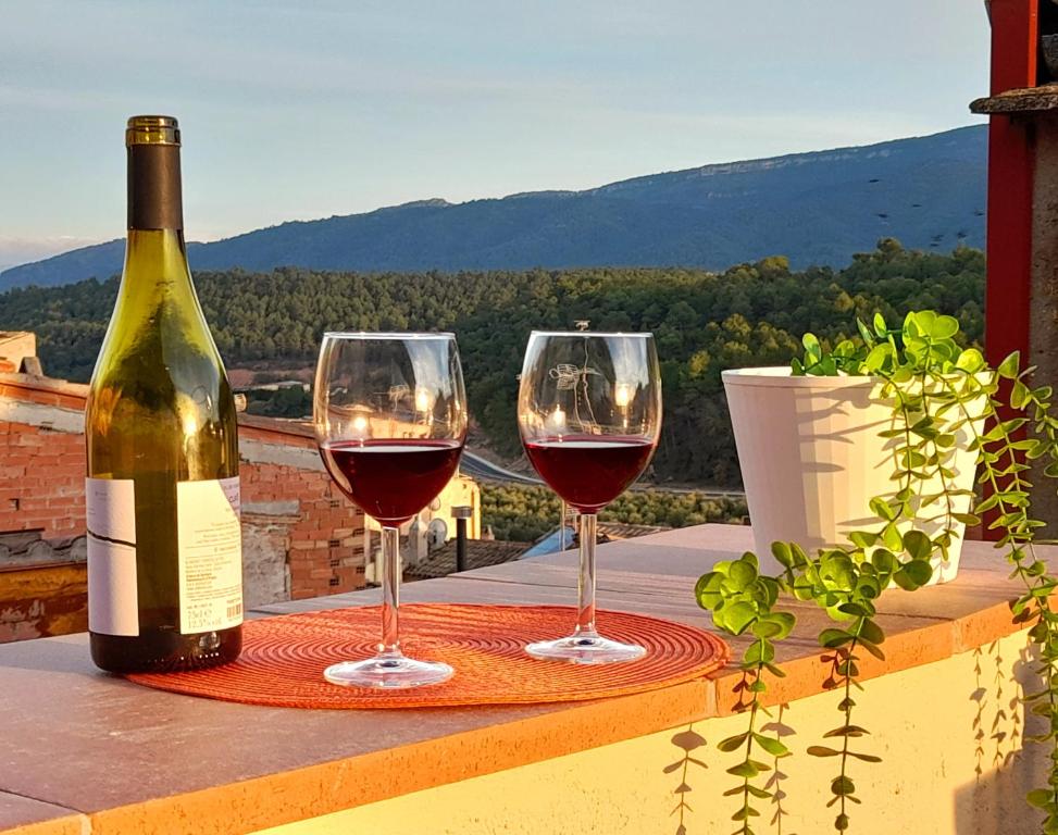 VimbodíCal Passió的桌子上放两杯葡萄酒,还有一瓶葡萄酒