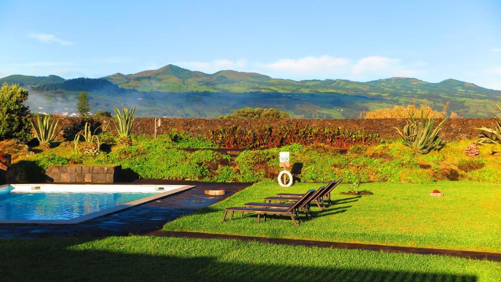 圣维森特费雷拉Sao Vicente Lodge - Atlantic Retreat的后院设有游泳池、2把椅子和1张桌子