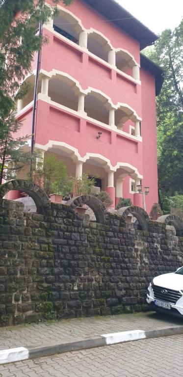 百乐·奥拉内斯蒂Casa Rosa的石墙后面的粉红色建筑