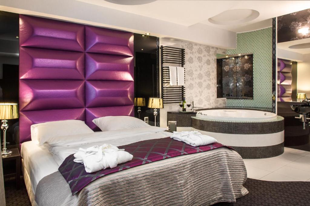 热舒夫吉莫维特酒店的一间卧室设有一张大床和一个浴缸