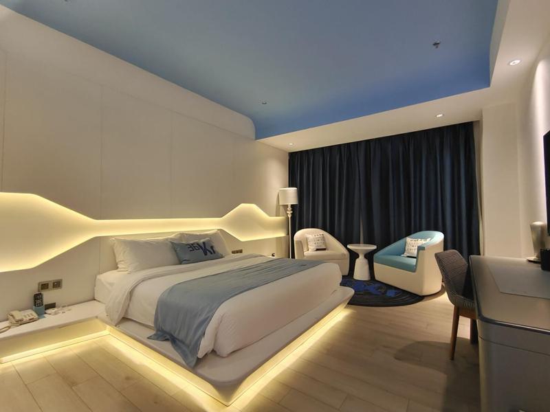 库尔勒巴州库尔勒市金都广场兰欧酒店的卧室配有一张白色大床和一张书桌