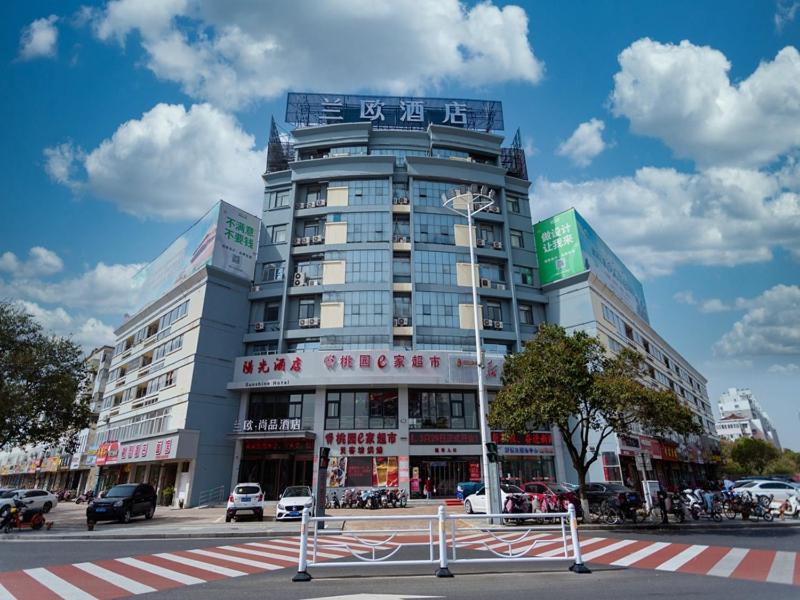 金湖淮安金湖苏宁广场健康西路兰欧尚品酒店的一座大型建筑,前面有汽车停放