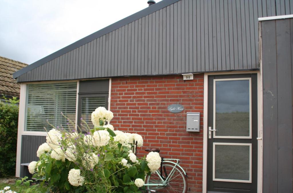 SchoorldamRekerlanden 90的停在砖砌建筑前面的自行车