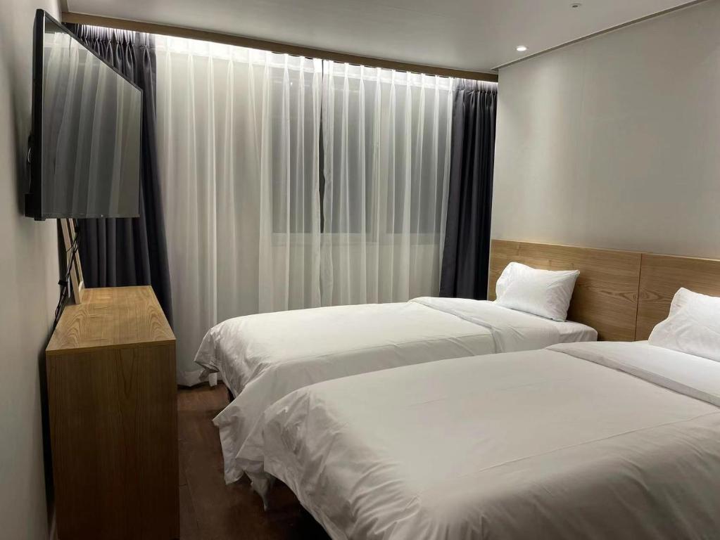 首尔The garden hotel的酒店客房设有两张床和窗户。