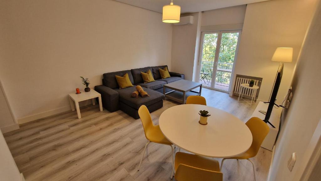马德里Espectacular apartamento en Cuzco / Alberto Alcocer的客厅配有沙发和桌子