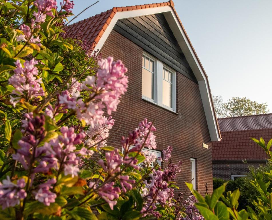 东卡佩勒Dunopark Villa的前面有粉红色花的房子