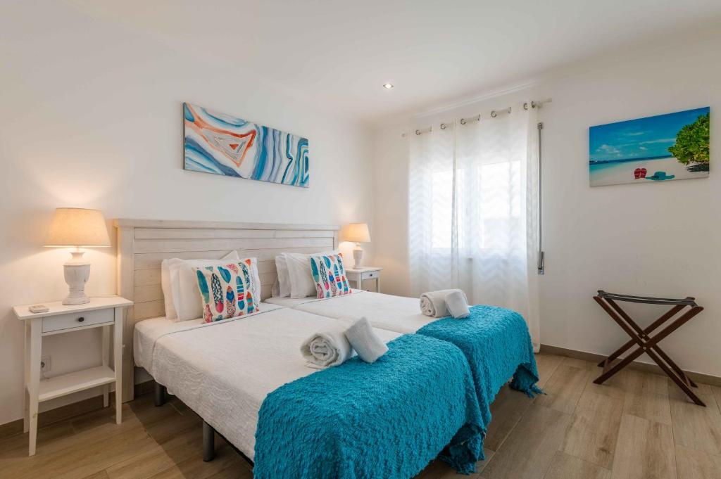 阿尔布费拉Casa Mar d'Alma的一间卧室配有两张蓝色床单