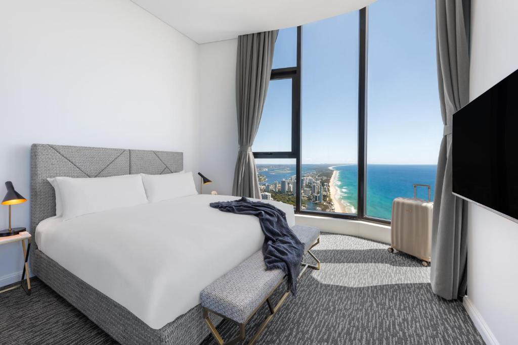 黄金海岸Meriton Suites Surfers Paradise的酒店客房设有一张床,享有海景。