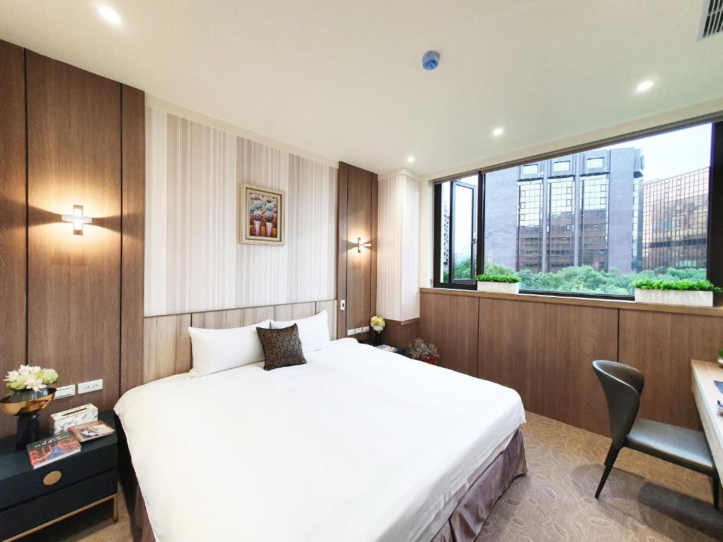 台北葛瑞丝商旅敦北馆的卧室设有白色的床和大窗户