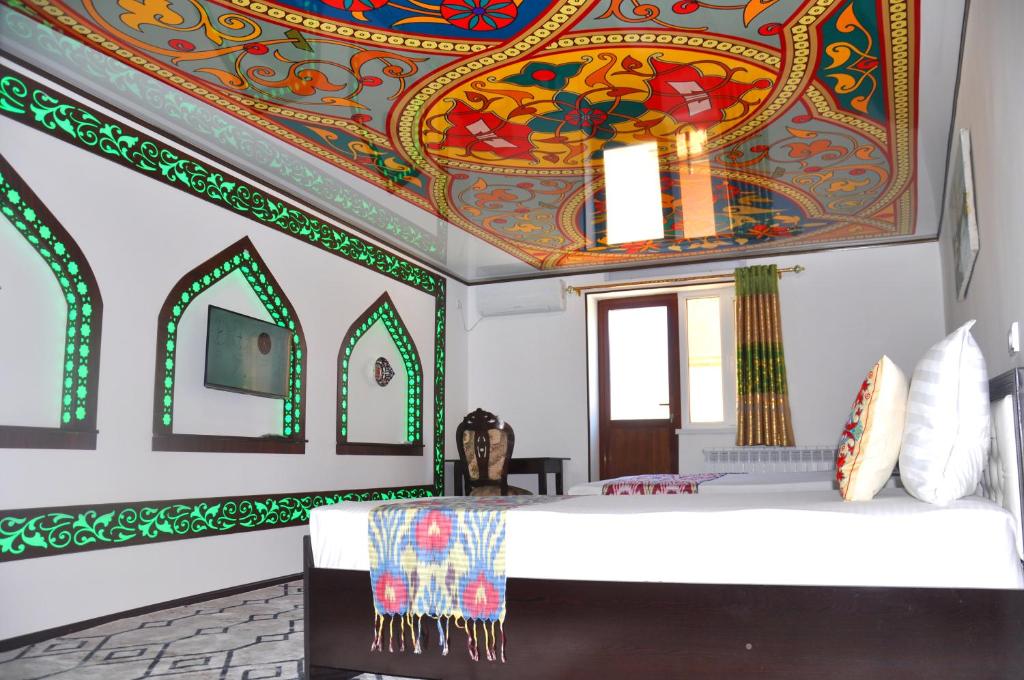 希瓦Khiva Tosh Darvoza的一间卧室设有色彩缤纷的艺术天花板