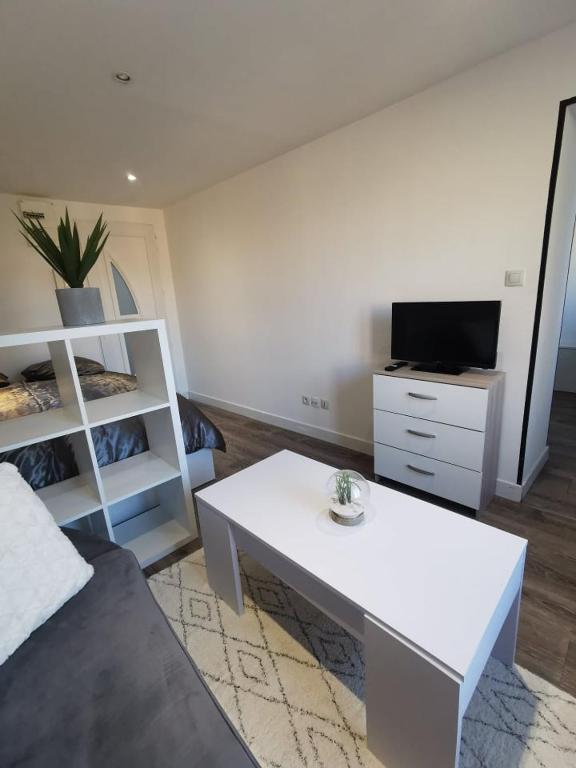 埃皮纳勒Le Cozy - Hyper centre - Calme - Moyenne durée的带沙发和白色桌子的客厅