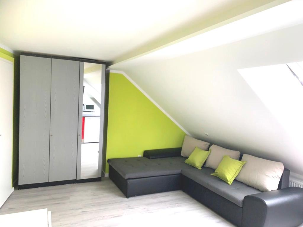 柏林Helles Apartment in Berlin-Mariendorf的带沙发和绿色墙壁的客厅