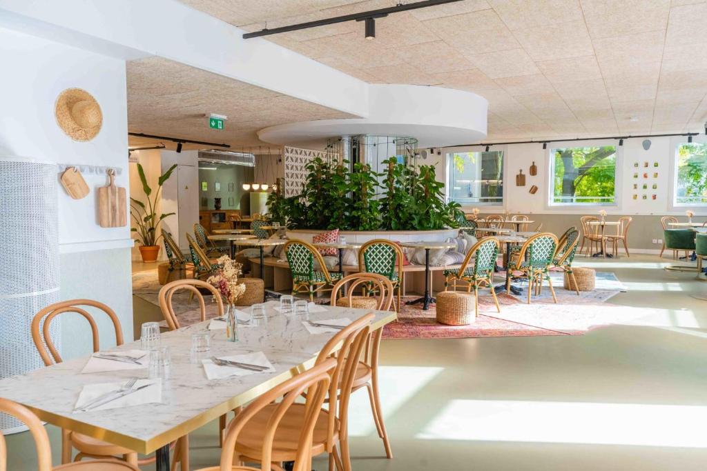 诺伊斯·勒·格兰德Ecla Paris Noisy-le-Grand的一间带桌椅的用餐室和一间餐厅