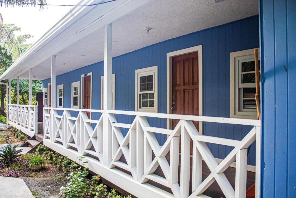 Six HutsCoco Bahia Apartment的白色的蓝色房屋,设有白色的围栏