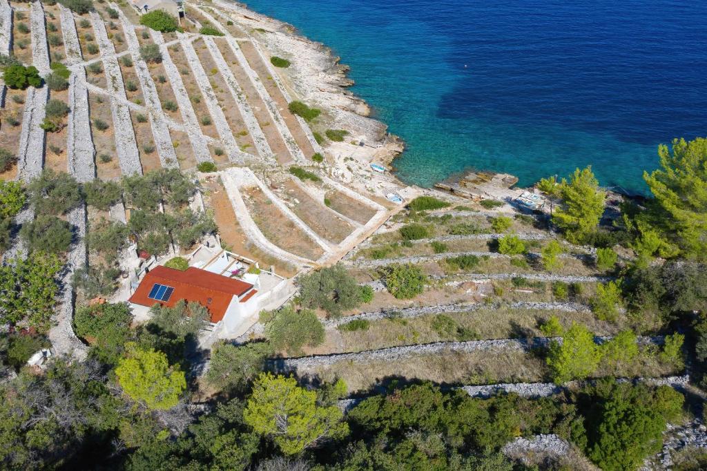 尼亚卢卡Secluded fisherman's cottage Cove Stiniva, Korcula - 11389的水边山丘上房屋的空中景观