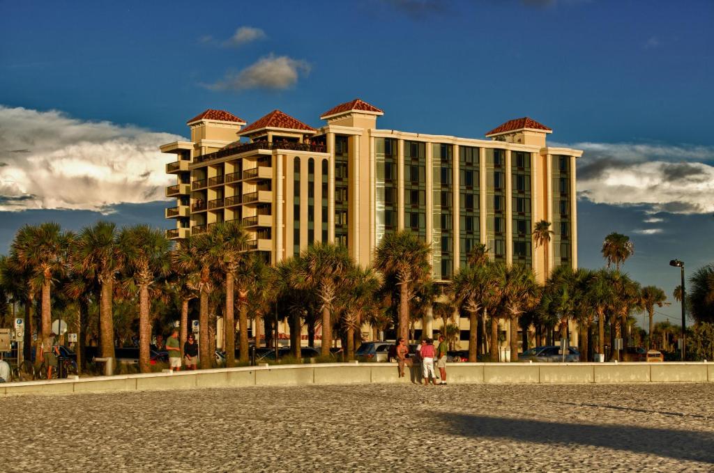 克利尔沃特Pier House 60 Clearwater Beach Marina Hotel的一座棕榈树环绕的大建筑