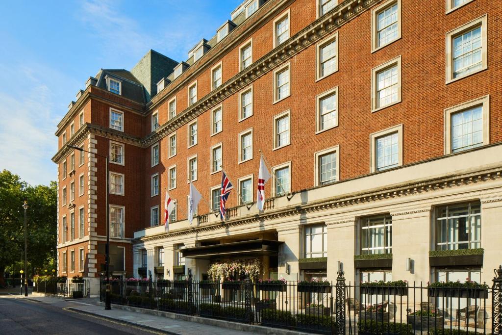 伦敦万豪伦敦格罗夫纳广场酒店的一座大型红砖建筑,上面有旗帜