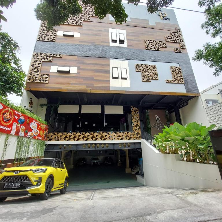 雅加达3 Point Syariah Residence的停在大楼前的黄色汽车