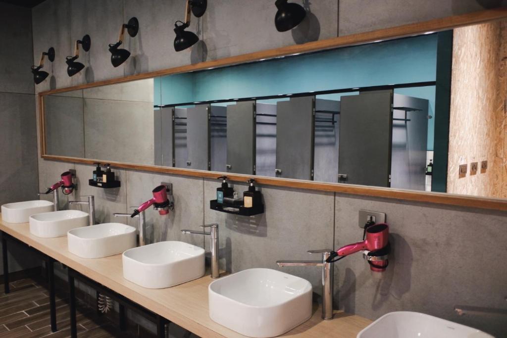 花莲市KID花莲背包客栈的一间带四个盥洗盆和大镜子的浴室