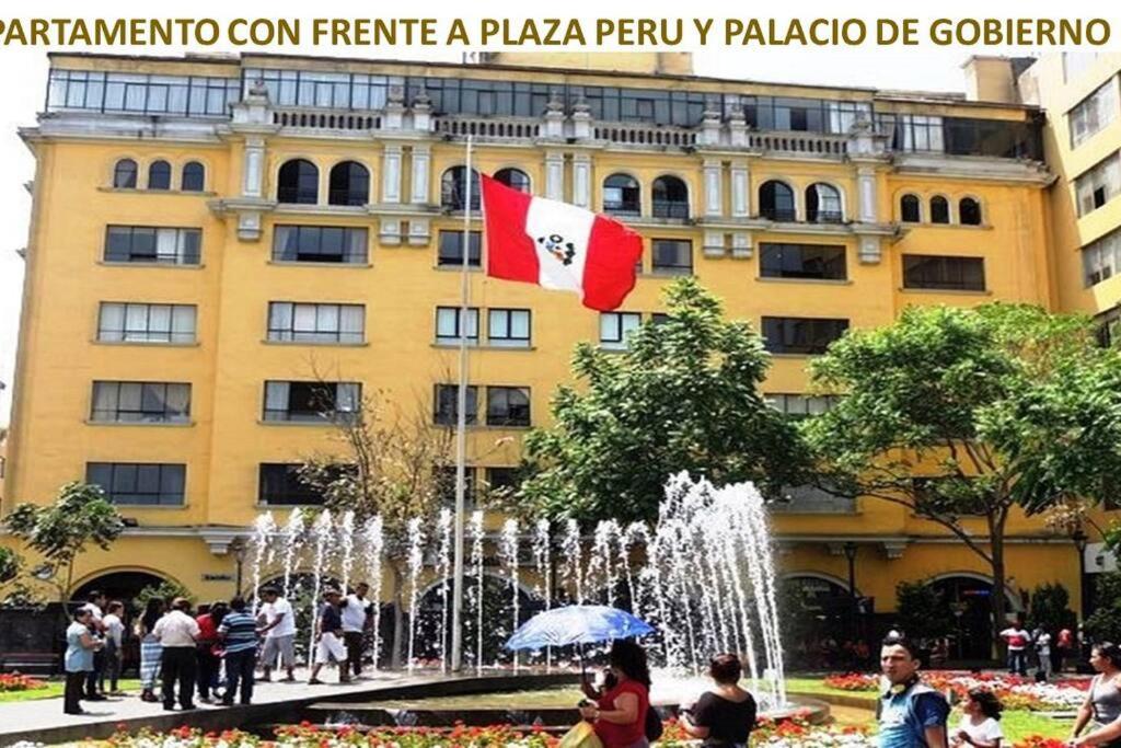 利马Apartamento frente al Palacio Gobierno的一座建筑物前方有旗帜的喷泉