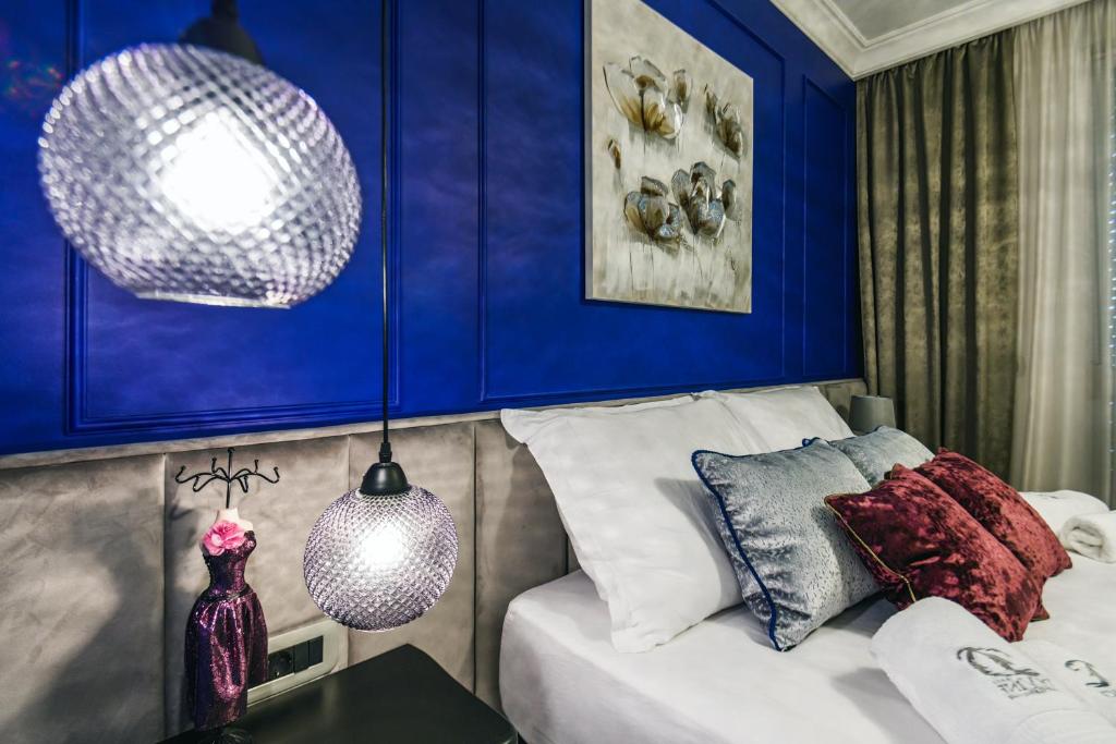 扎达尔DiVine Luxury Apartment Blue的一间卧室设有蓝色的墙壁和一张带桌子的床