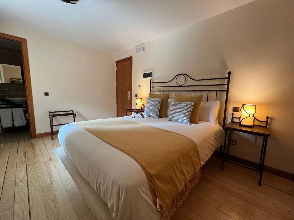 塞尔塞迪利亚Corzo Hotel的一间卧室配有一张带两盏灯的大型白色床。