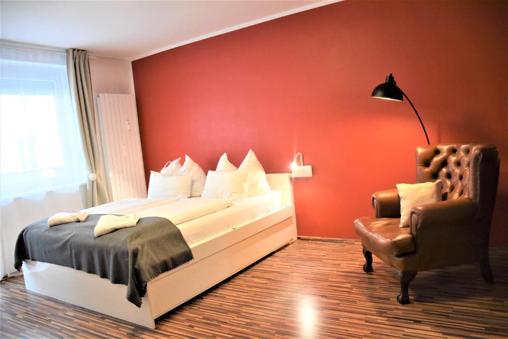 维也纳奥加唐公寓的红色卧室配有床和椅子