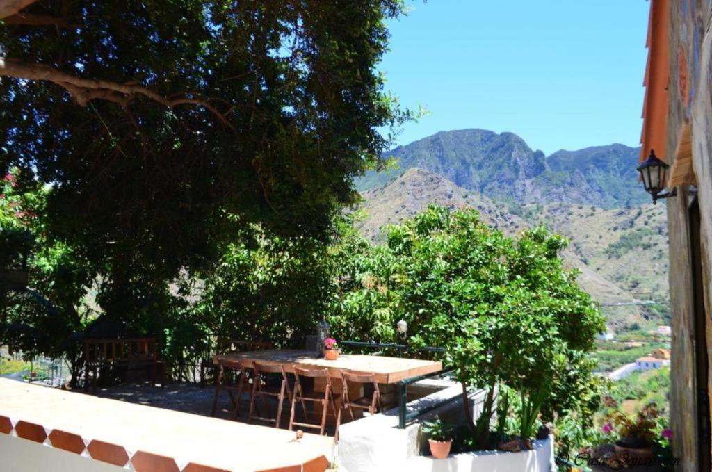 埃尔米瓜Casa rural con Wifi y estupenda vista a la montaña en Hermigua的阳台的桌子,背景是山脉