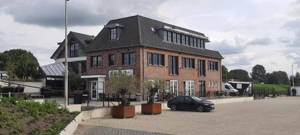 KerkdrielSientjes Boetiekhotel的停在砖楼前的黑色汽车