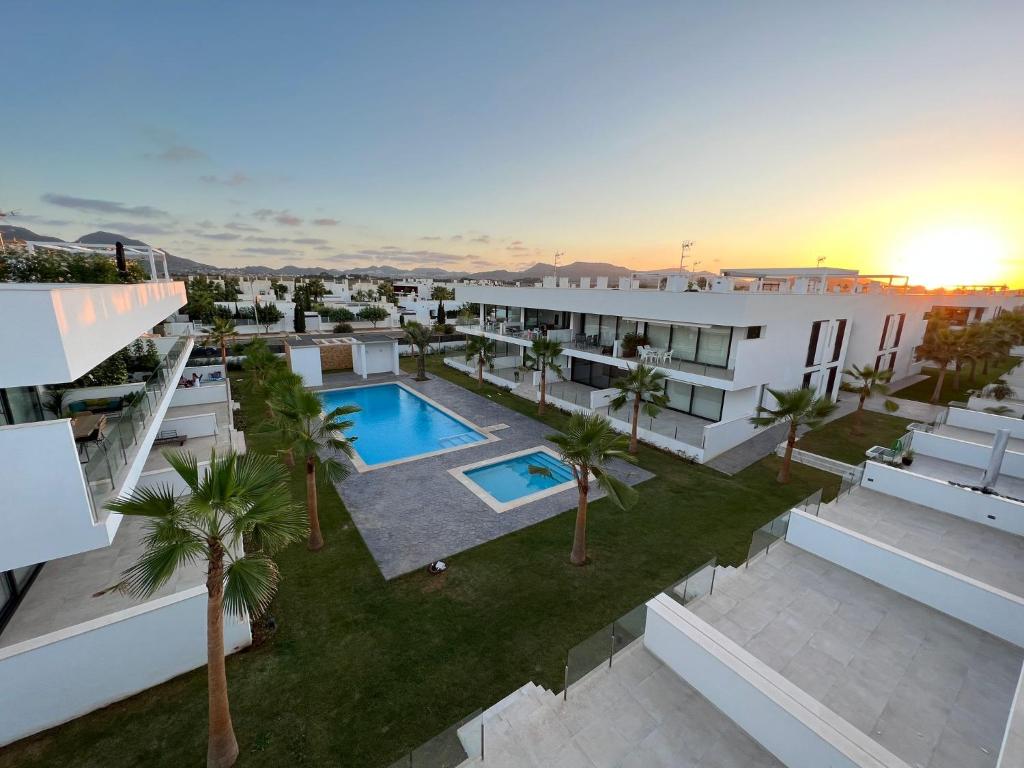 马尔德·克里斯塔尔Outstanding 2 bed apartment with rooftop sea views的享有带游泳池和棕榈树的建筑的空中景致