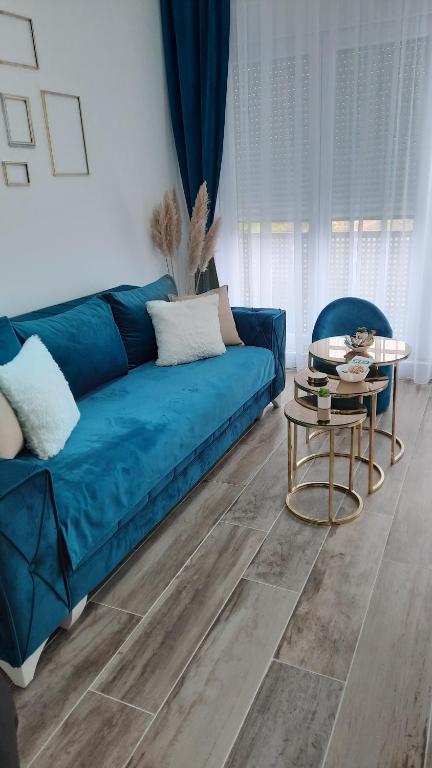 帕拉钦Apartman Diamond的客厅配有蓝色的沙发和桌子