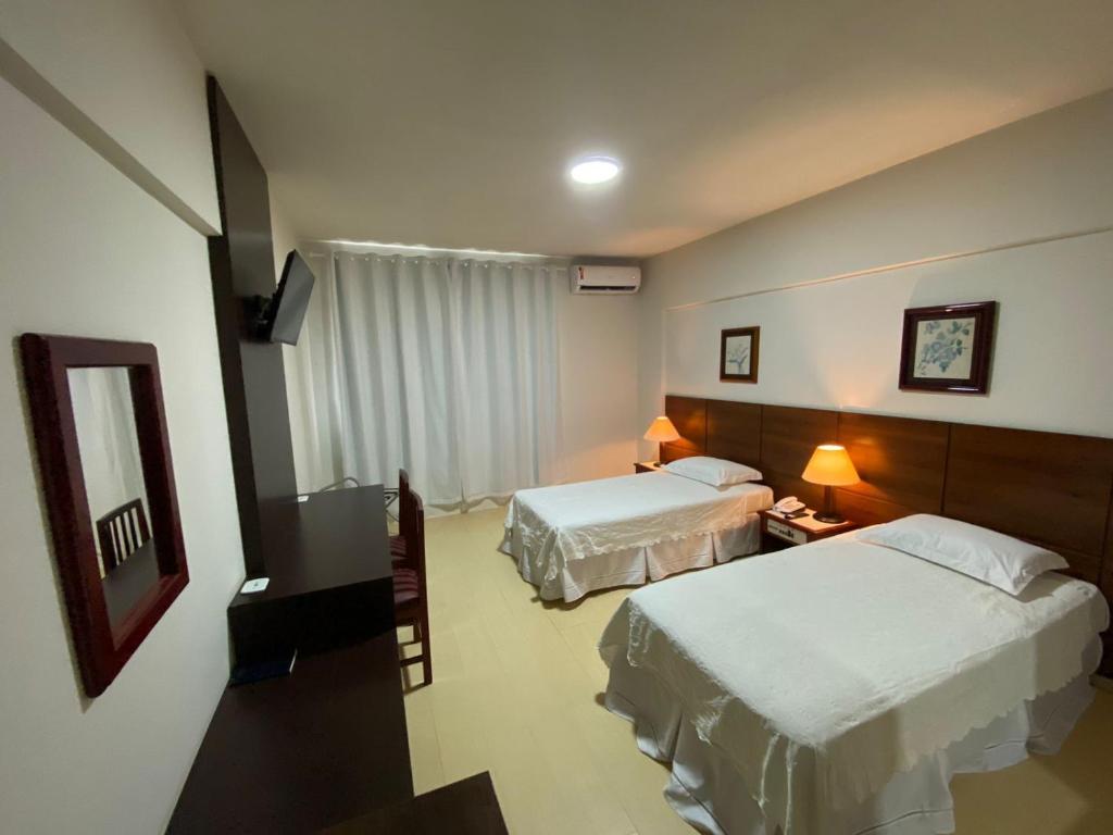波多韦柳AQUARIUS HOTEL的酒店客房,设有两张床和镜子