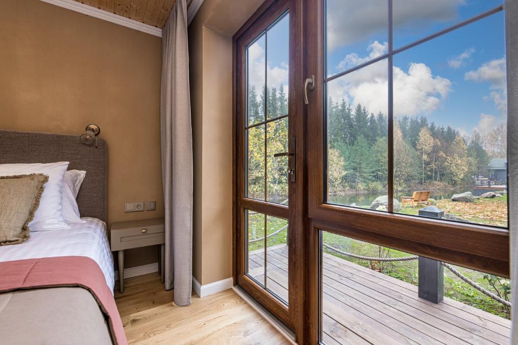 Želvė Village & SPA的一间卧室设有一张床和一个大窗户