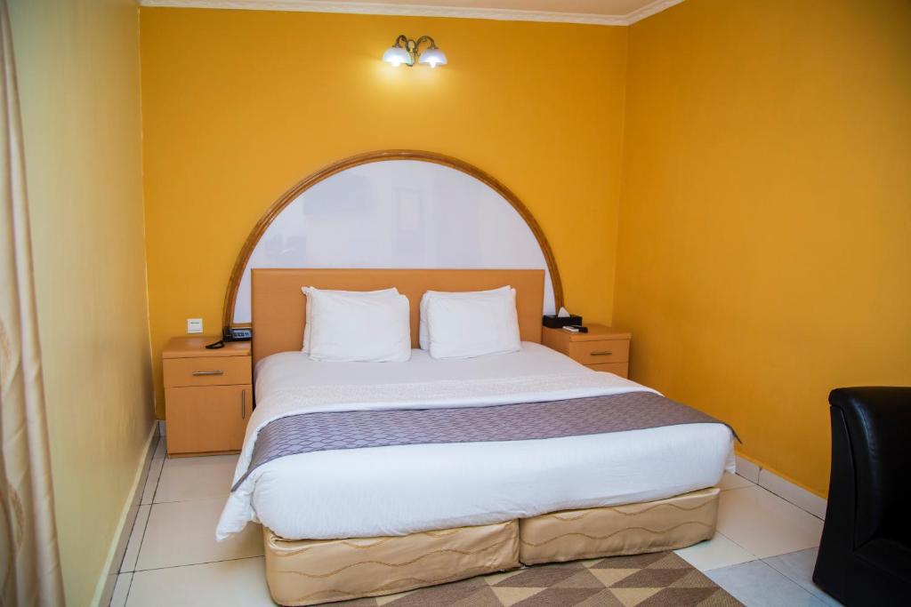 阿克拉禁区酒店的一间卧室设有一张大床和拱形窗户
