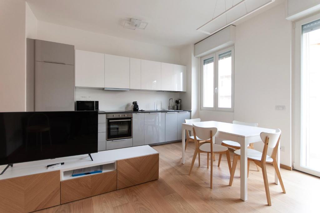 米兰YouHosty - Del Castagno 2的白色的厨房配有桌椅和电视。